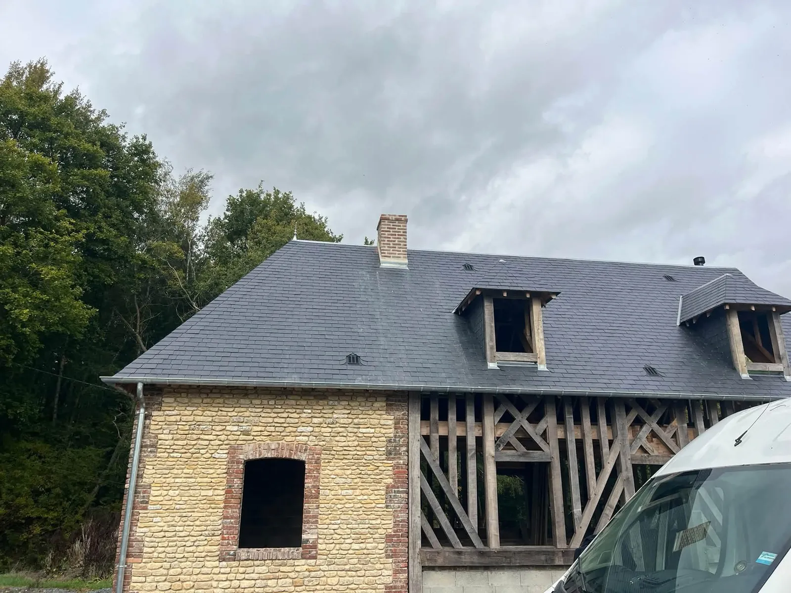 Toiture en ardoises avec lucarnes et souche de cheminée en brique, couvreur à Louvigny