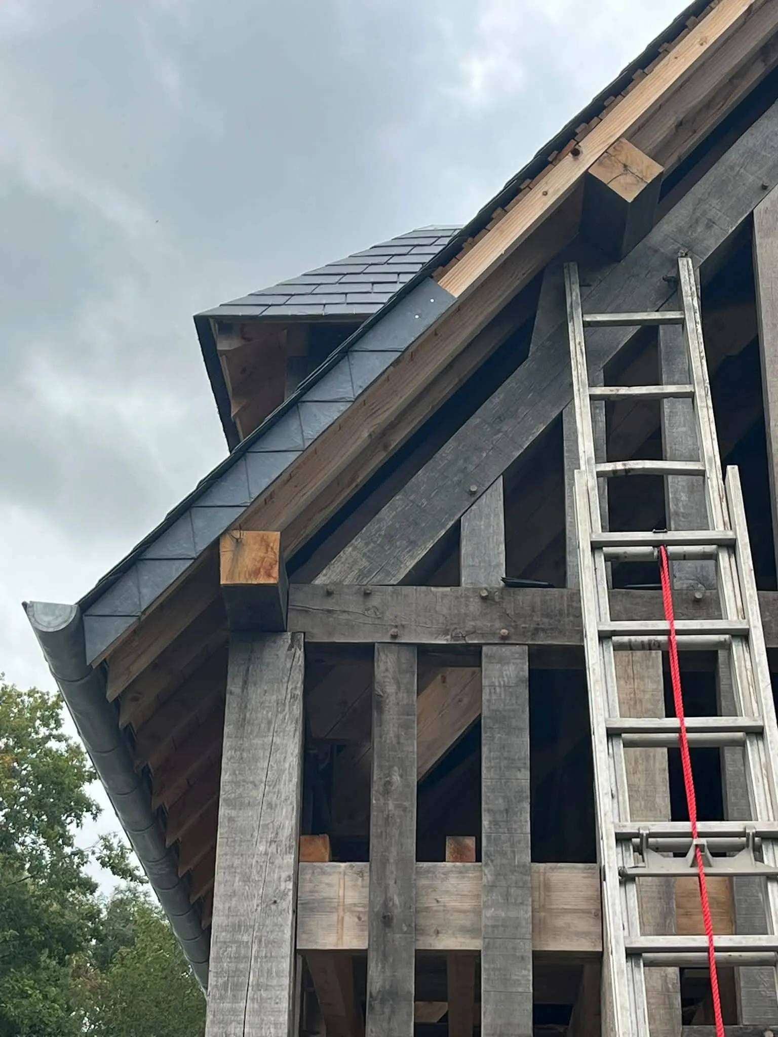 Détail d'un égout de toit en ardoises avec gouttière zinc sur une charpente en chêne, couvreur à Argentan