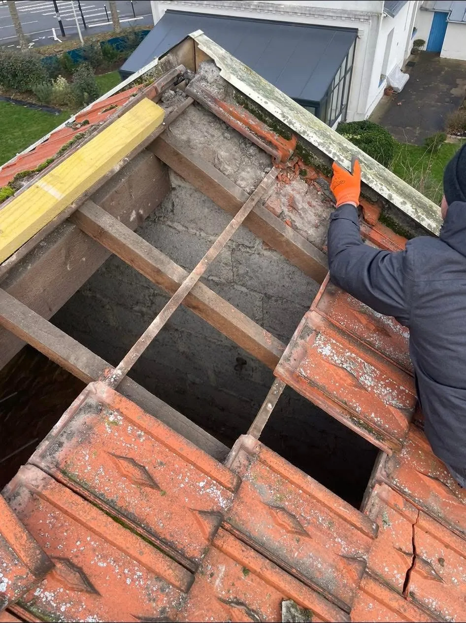 Couvreur au travail sur un arêtier de toiture en tuiles, dépose des éléments pour réparation, couvreur à Livarot