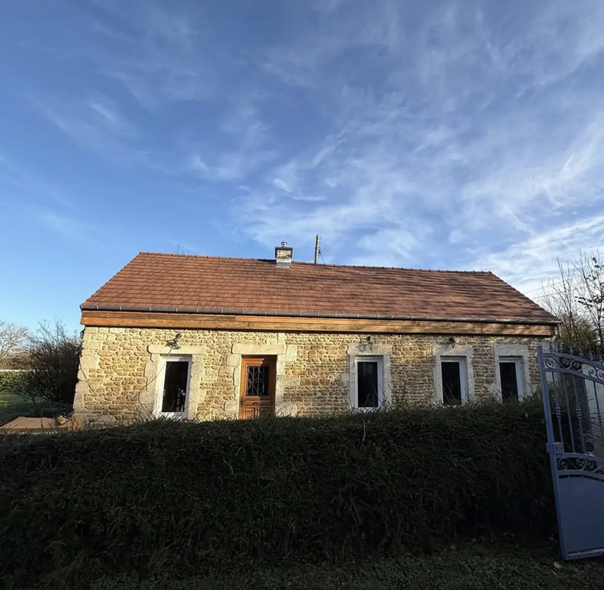 Toiture en tuiles plates rouges sur une maison en pierre avec gouttières, couvreur à Livarot